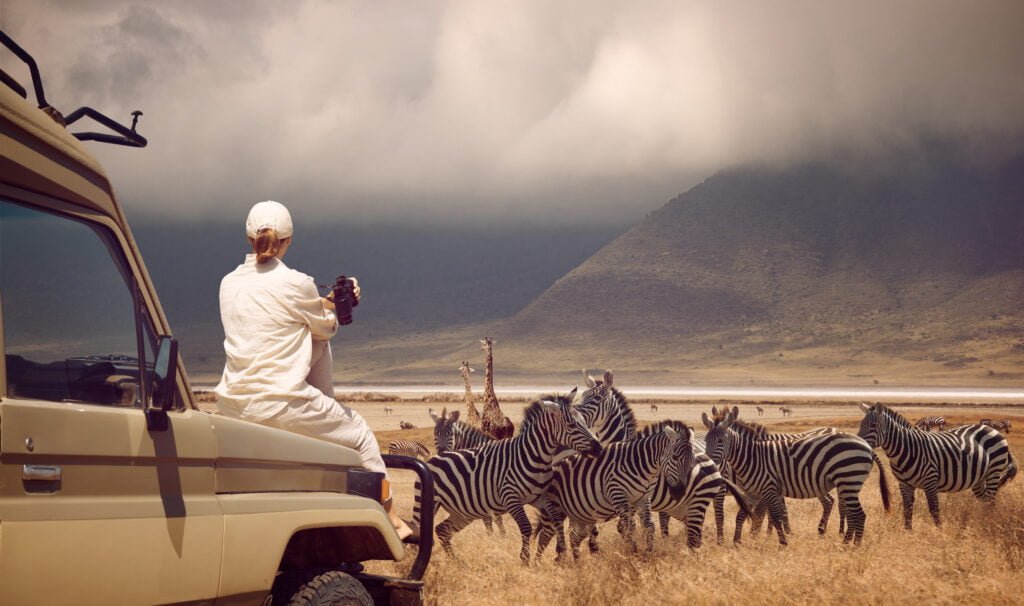 Woman traveler on safari-tour in Africa, traveling by car in Tan